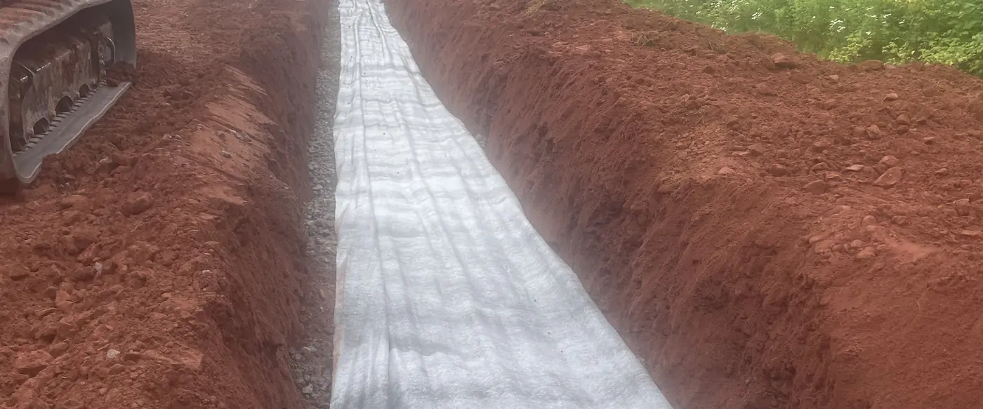 Long fabric-lined trench prepared for a septic installation