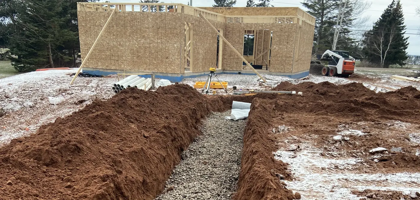 Gravel trench prepared beside a new house frame
