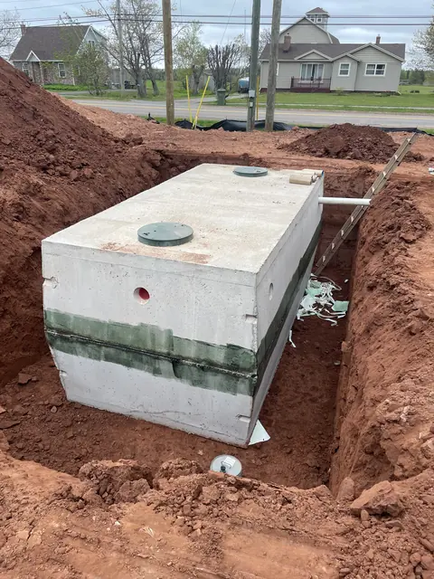 Concrete septic tank set in an excavated red-soil bed